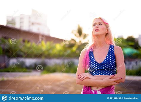 Young Beautiful Blonde Woman With Arms Crossed In The Streets Outdoors