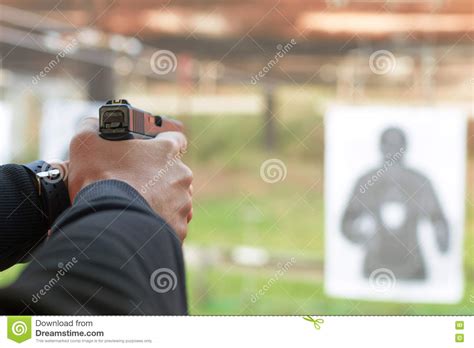 Tiro Uma Pistola Homem Que Aponta A Pistola Na Escala De Tiro Foto