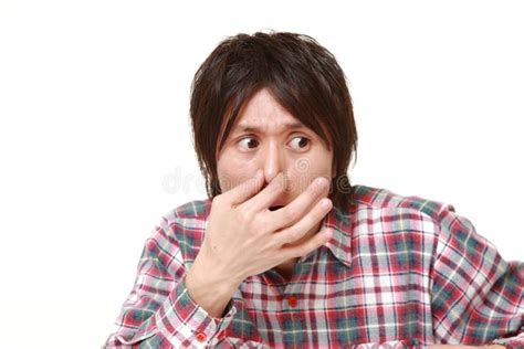 Young Japanese Man Holding His Nose Because Of A Bad Smell Stock Image