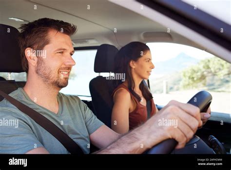 Mid Adult White Man Driving Car His Wife Beside Him In Front Passenger