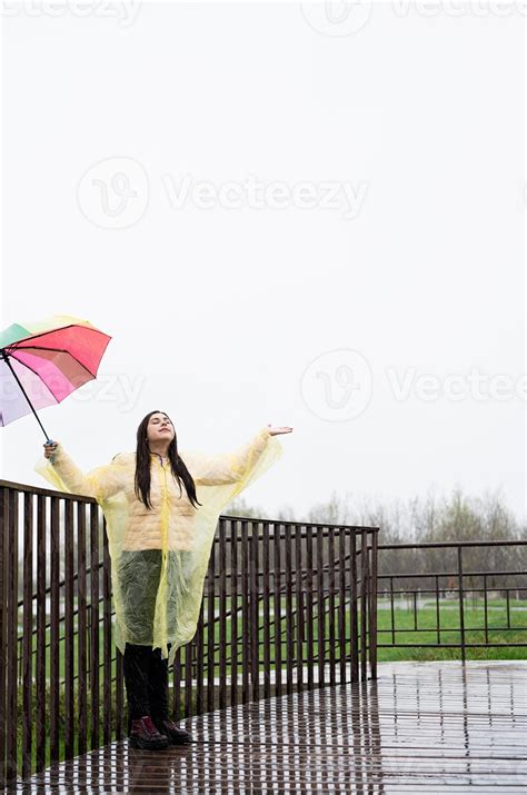 Beautiful Brunette Woman Holding Colorful Umbrella Out In The Rain