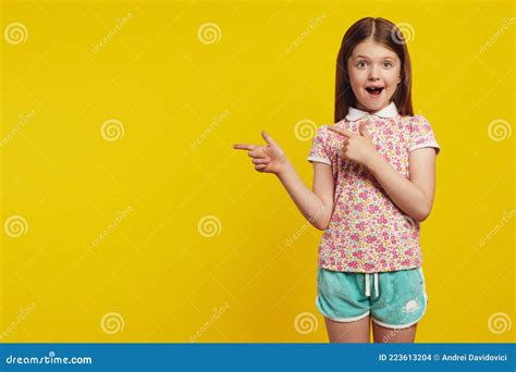 étonné Jeune Fille Mignonne Pointes Avec Les Deux Doigts Avant Montre Espace Vide Photo Stock