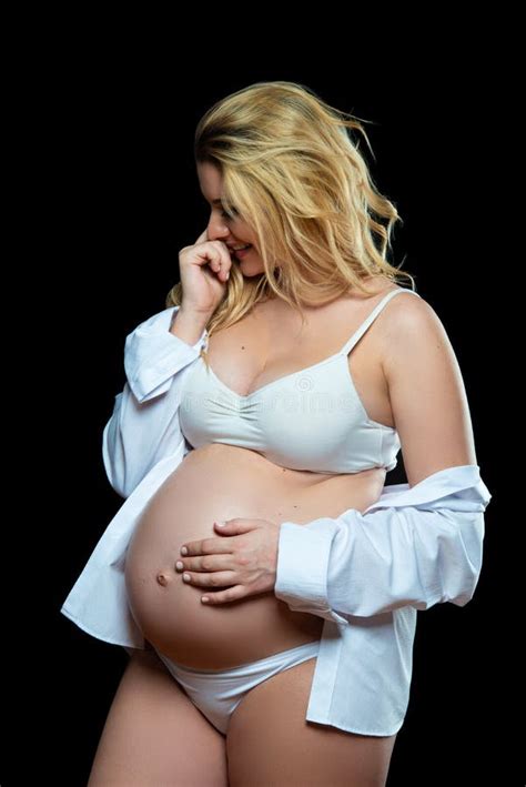 Beautiful Smiling Blonde Pregnant Woman In White Clothes On A Black