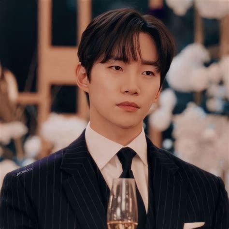 A Man In A Suit And Tie Holding A Glass Of Wine