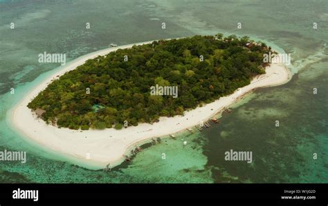 Tropical Island And Sandy Beach Surrounded By Atoll And Coral Reef With