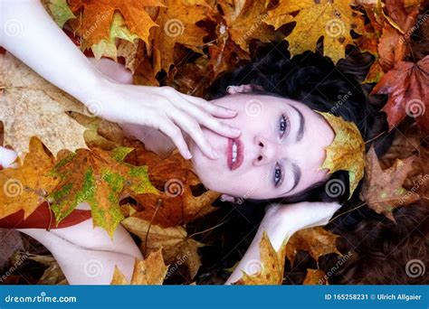 Portrait Of A Cute Young Girl Covered With Red And Orange Autumnal