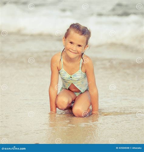 Menina Que Senta Se Na Praia Foto De Stock Imagem De Areia Nave