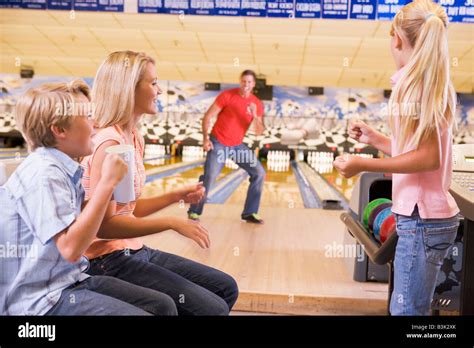 Family in bowling alley smiling Stock Photo - Alamy