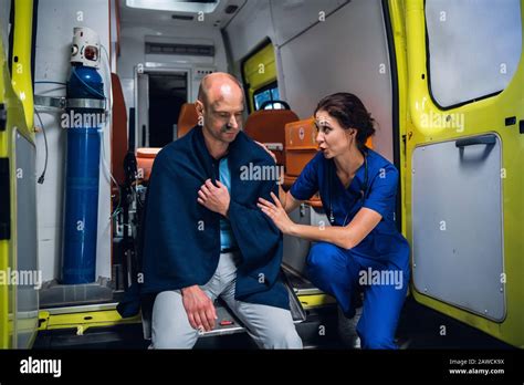 Paramedic In Blue Medical Uniform Talks With Man And Puts Her Hands On