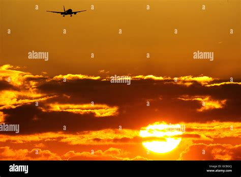 A Plane Arrives At Heathrow Airport As The Sun Rises Over London