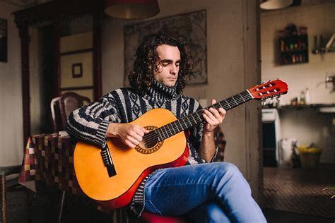 "Young Bohemian Man Playing Acoustic Guitar" by Stocksy Contributor "Lucas Ottone" - Stocksy