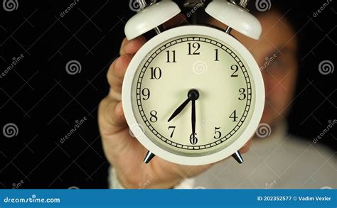 730 O`clock Human Hand Holding Alarm Clock That Showing Seven Thirty