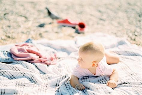 O Beb Est Deitado De Bru Os Em Um Cobertor Na Praia E Desvia O Olhar