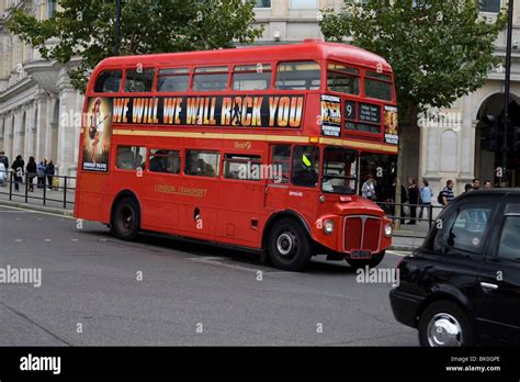 Red Routemaster Rm1614 Bus Following A Black Taxi Cab In Londons