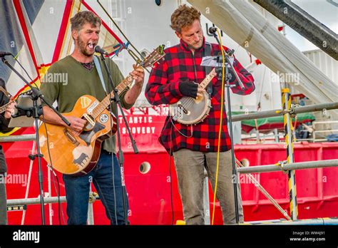 Two members of a sea shanty folk band playing their instruments and ...