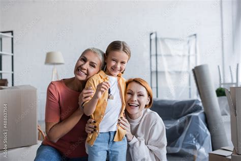 Foto De Preteen Girl Holding Key Near Happy Same Sex Parents In New