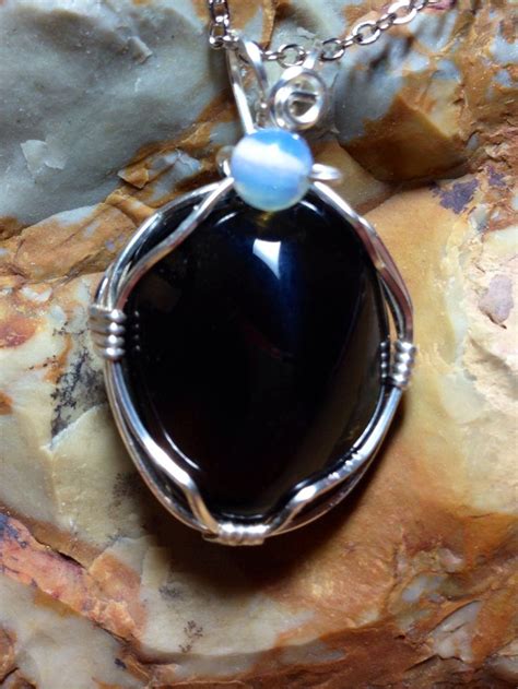 Wire Wrapped Apache Tear Accented With A Round Opalite Bead Perfume