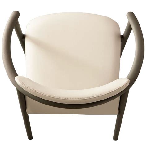 A White Leather Chair With Curved Arms