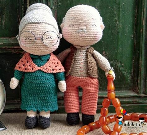 Two Crocheted Dolls Standing Next To Each Other