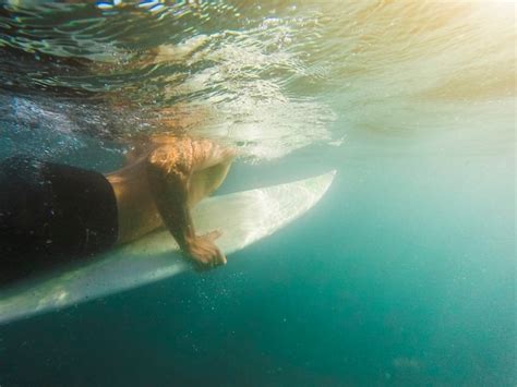 Jeune Homme Nageant Sur Une Planche De Surf Dans L Eau Bleue Photo