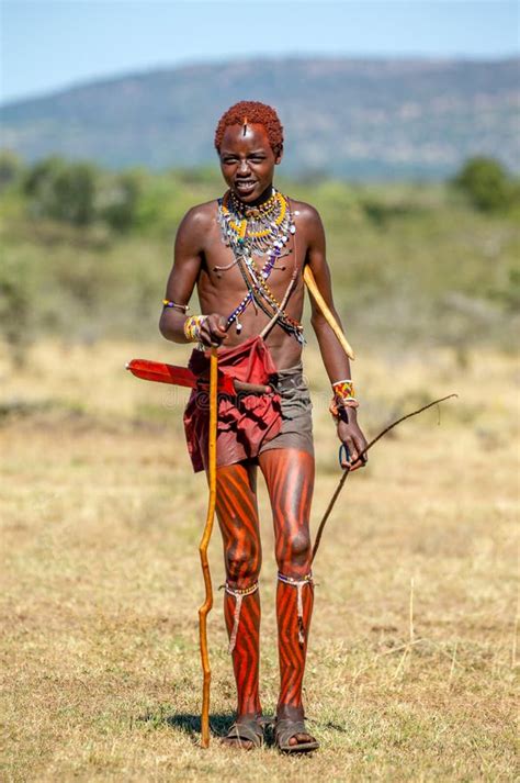 Masai Man In Traditional Dress Is Standing In The Savannah Editorial