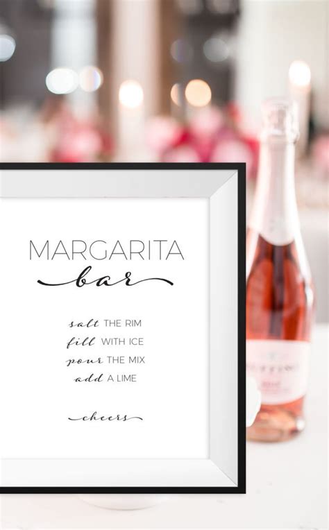 A Bottle Of Wine Sitting Next To A Framed Sign With The Words Margarita