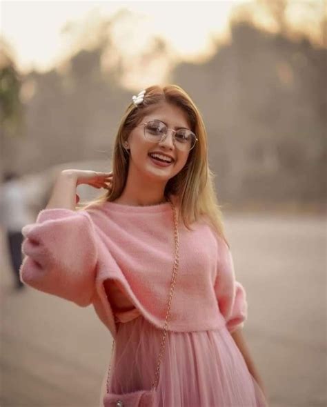 A Woman Wearing Glasses And A Pink Dress Poses For The Camera With Her