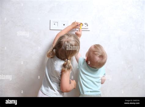 Little Children Playing With Electrical Socket Indoors Back View