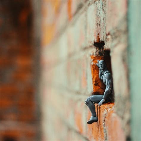 Action Figure On A Hole Of Brick Wall · Free Stock Photo