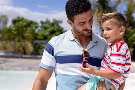 Padre Birracial Feliz E Hijo Abrazándose En La Piscina Foto de archivo