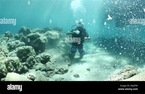 Man Scuba Diver Making Air Bubbles Under Boat Underwater Sun Beams And