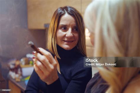 Mature Caucasian Woman At Kitchen In Front Tap At Home Smoking Holding