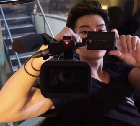 a woman holding up a camera next to stairs