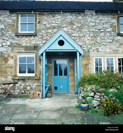 Paved Area In Front Of Stone Country Cottage With Blue Painted Wooden