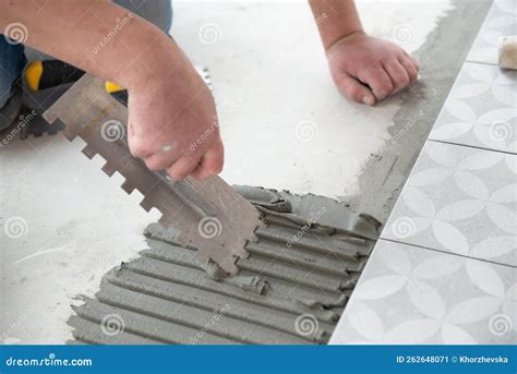 Tiler Laying The Ceramic Tile On The Floor Professional Worker Makes