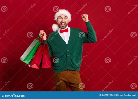 Photo Of Funny Xmas Guy Wear Cardigan With Bowtie Fists Up Hold Stack Shopping Bargains