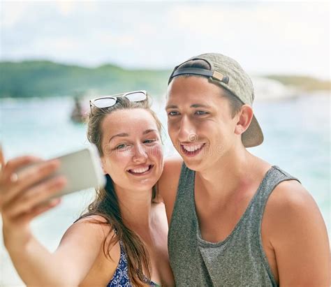 Beach Selfies Are A Must A Happy Couple Taking A Selfie On The Beach