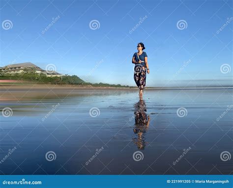 Una Mujer Feliz Caminando Sola En La Playa Sobre Un Fondo Azul Claro Y