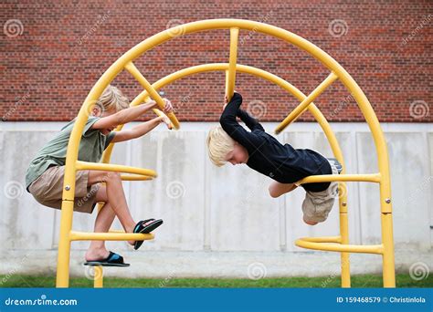 Little Kids Climbing On Jungle Gym Bars At Playground At School Stock