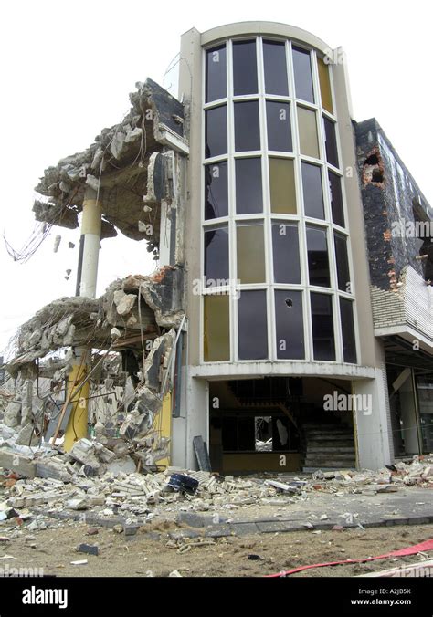 Part Of Broken Down Building Still Standing Among Rubble And Debris