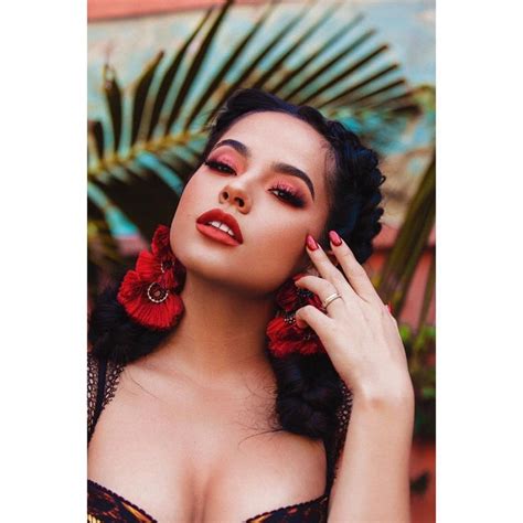 A Woman With Red Lipstick And Large Earrings On Her Head Is Posing In