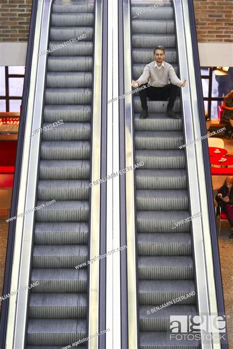 Man Sitting On Escalator Stock Photo Picture And Rights Managed Image