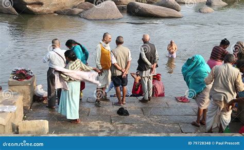 Indian People Standing At The Riverbank And Taking Bath In The