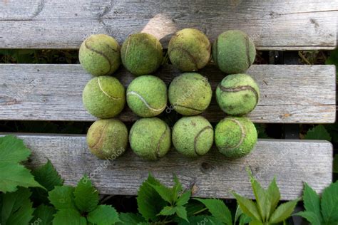 Pelotas De Tenis Viejas Y Sucias Yacen En Un Banco De Madera Concepto