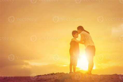 Silhouette Of A Mother Kissing His Son In A Forehead On The Sunset Summer Day 7708329 Stock