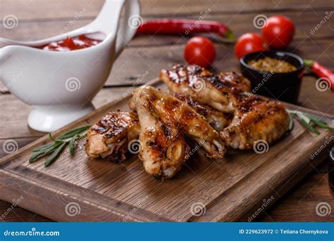 Grilled Spicy Chicken Wings On A Dark Background With Spices And Herbs