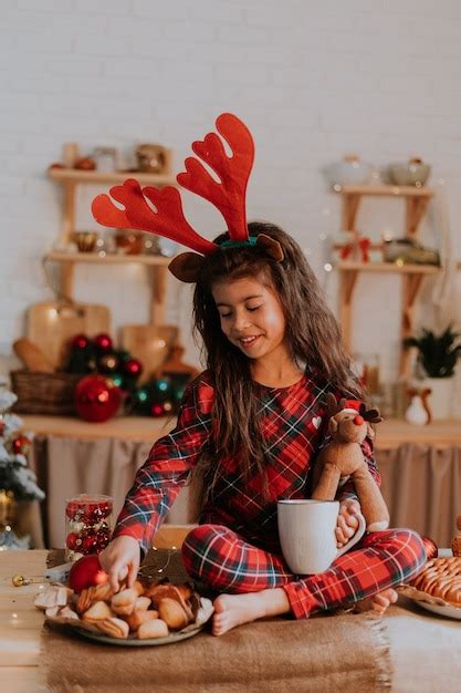 Jolie Petite Fille Brune En Pyjama Rouge à Carreaux Avec Des Cornes De