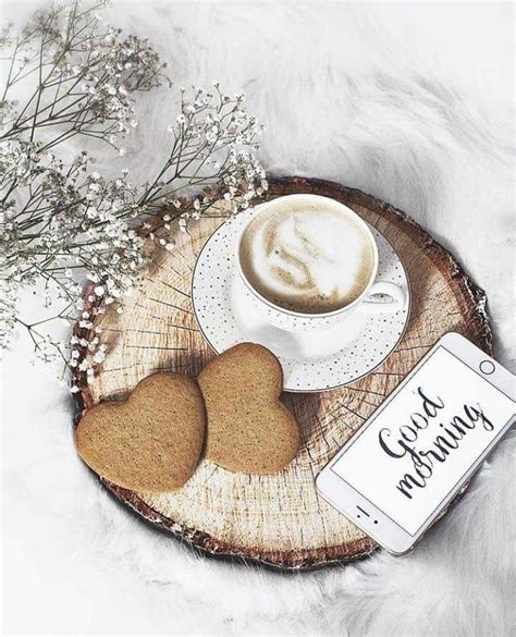 Two Heart Shaped Cookies Sitting On Top Of A Wooden Plate Next To A Cup