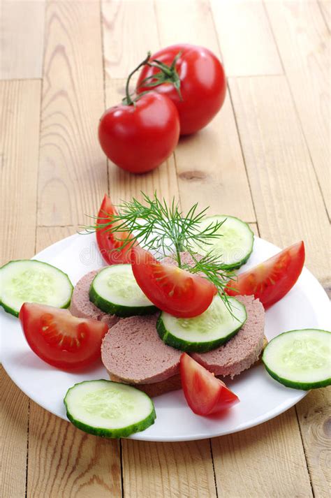 Bocadillo Con La Salchicha El Pepino Y El Tomate De Hígado Foto de