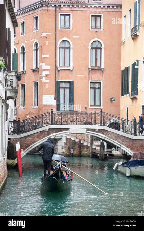 Couple Taking A Romantic Gondola Ride Through The Canals In Venice